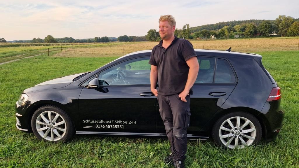 Inhaber mit Schwarzem Auto und Werbung