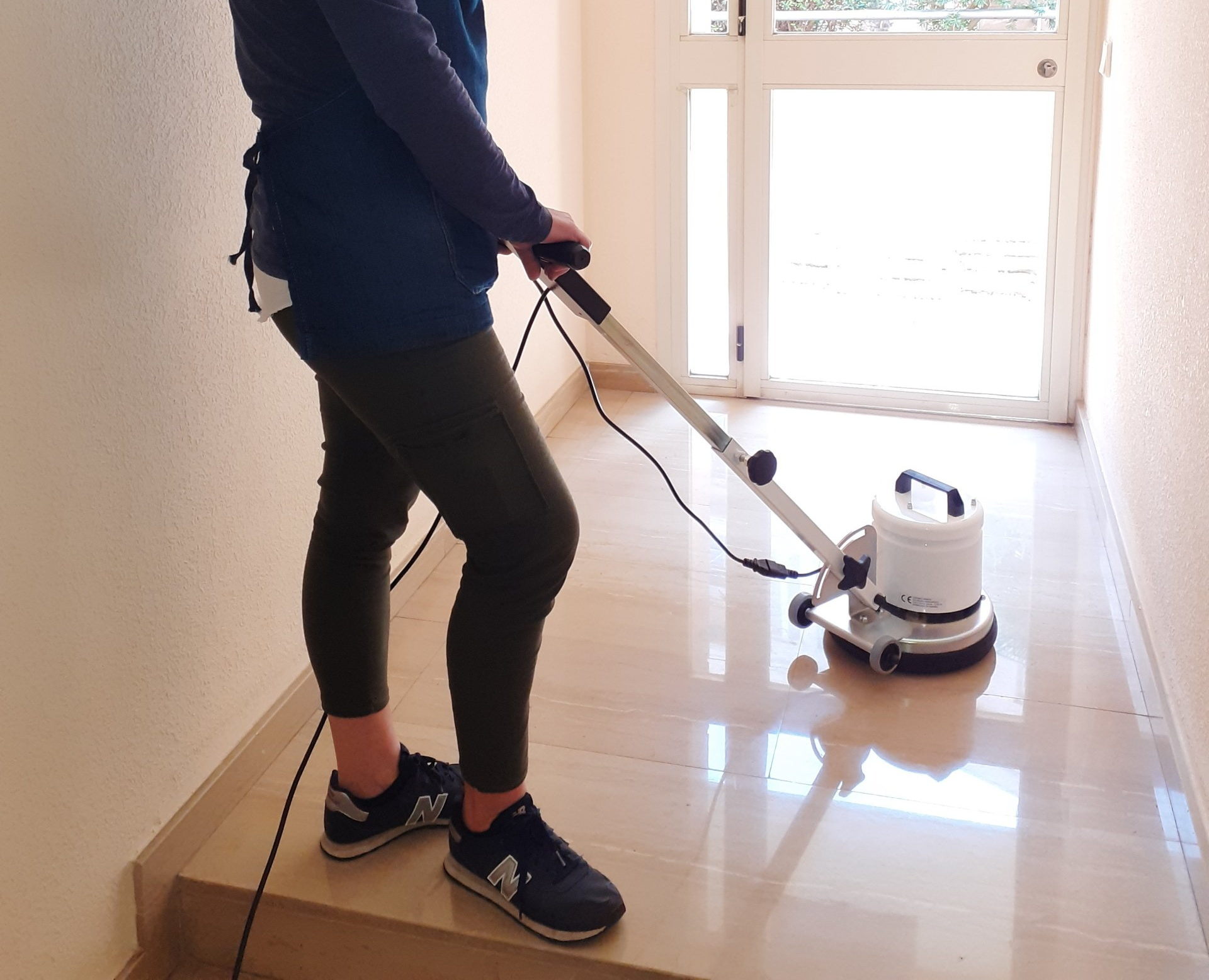 mujer puliendo el suelo con una máquina pulidora rotativa