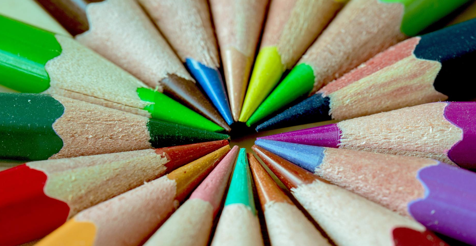 Bunte Stifte mit der Spitze zueinander zeigend kreisförmig angeordnet