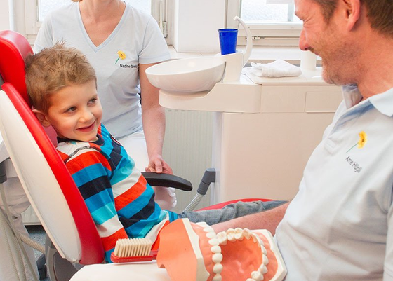 Zahnarzt Arne Hügli im Gespräch mit einem kleinen Jungen bei der Zahnputzschule