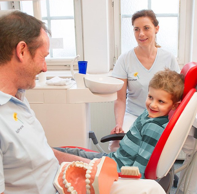 Zahnarzt Arne Hüglich im Gespräch mit einem Jungen in der Zahnputzschule