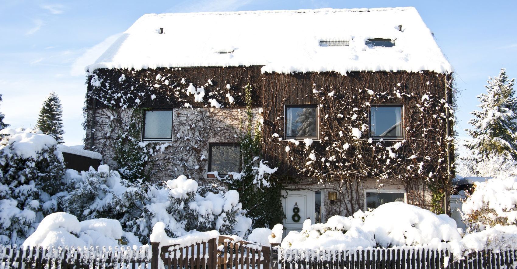 Ein Haus dessen Dach mit Schnee bedeckt ist