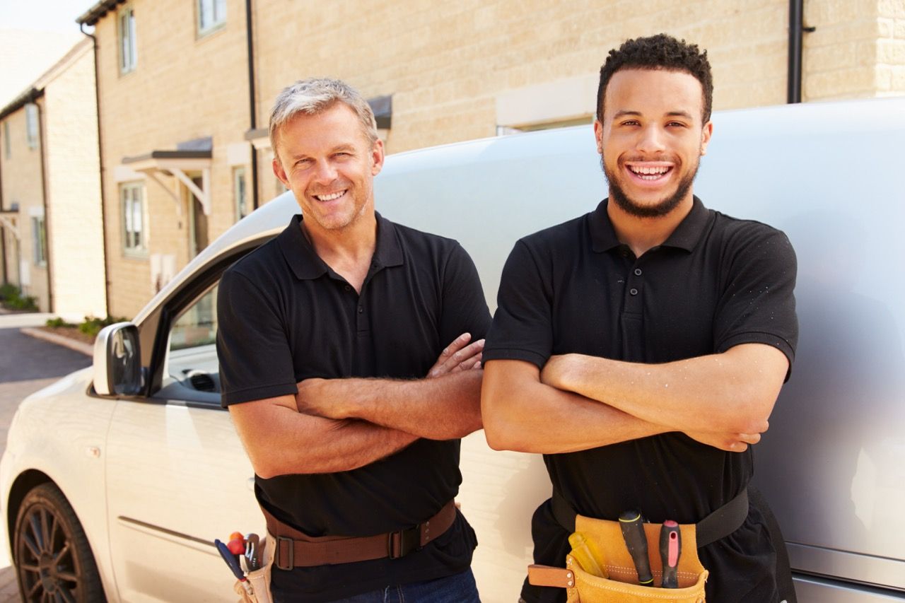 zwei Handwerker vor einem Auto