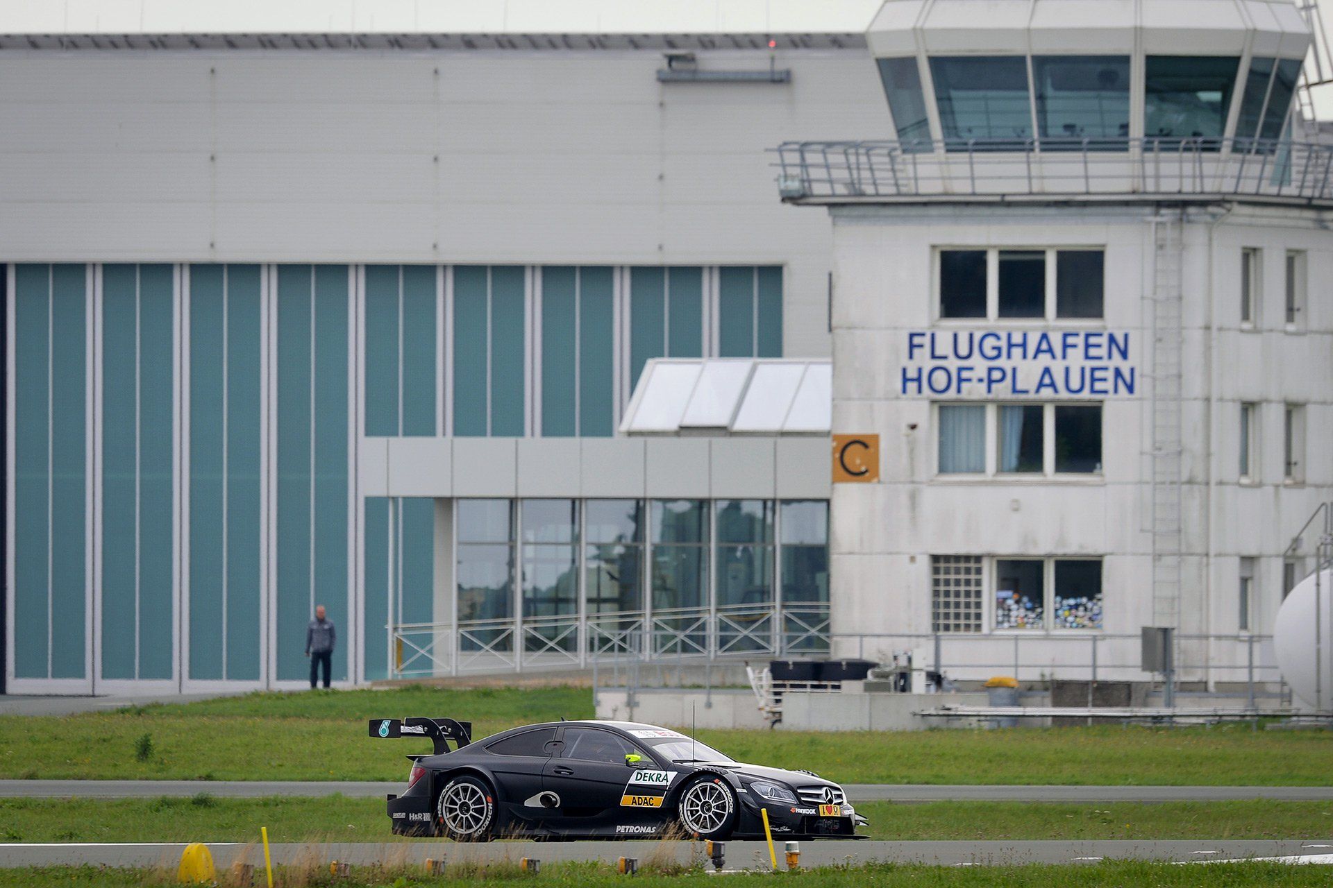 Der deutsche DTM-Rennfahrer Pascal Wehrlein steuert seinen Mercedes AMG C-Coupe am 28.08.2013 auf der Landebahn des Flughafen Hof-Plauen (Bayern) am Tower vorbei. Der Flughafen Hof-Plauen wird möglicherweise künftig regelmäßig für Testfahrten der Deutschen Tourenwagen-Masters (DTM) genutzt. Foto: David Ebener/dpa