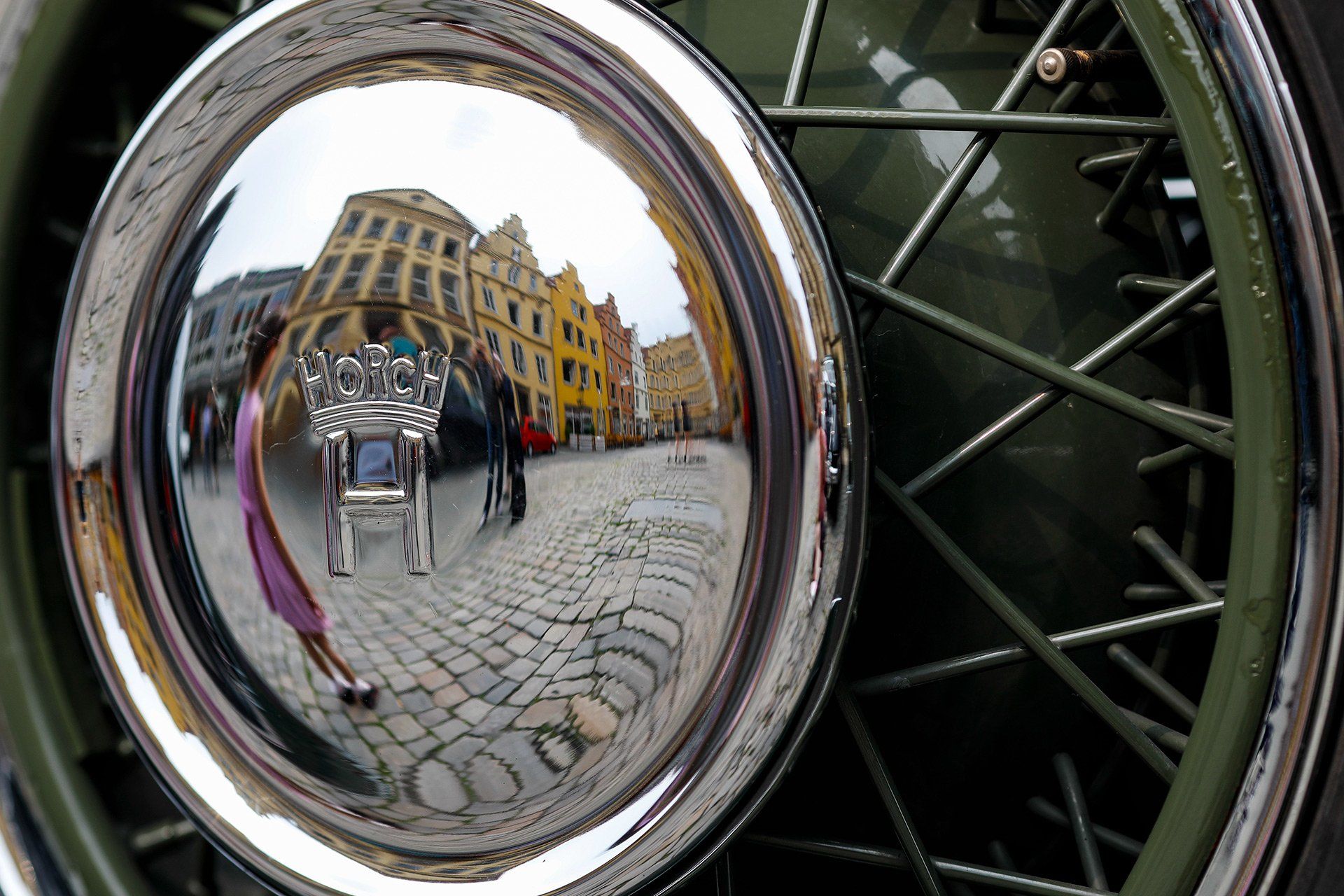 The colourful gabled houses are reflected in a chrome hubcap – more than two dozen vehicles from Horch, the predecessor of Audi, are parked on the market square in front of the historic town hall in Osnabrück on 1 June 2018. Photo: David Ebener ***Keywords*** Symbolic image, symbolic photo, illustration, Horch cars on the town hall square, vintage cars, classic cars, Audi, Auto Union, passenger cars, logo
