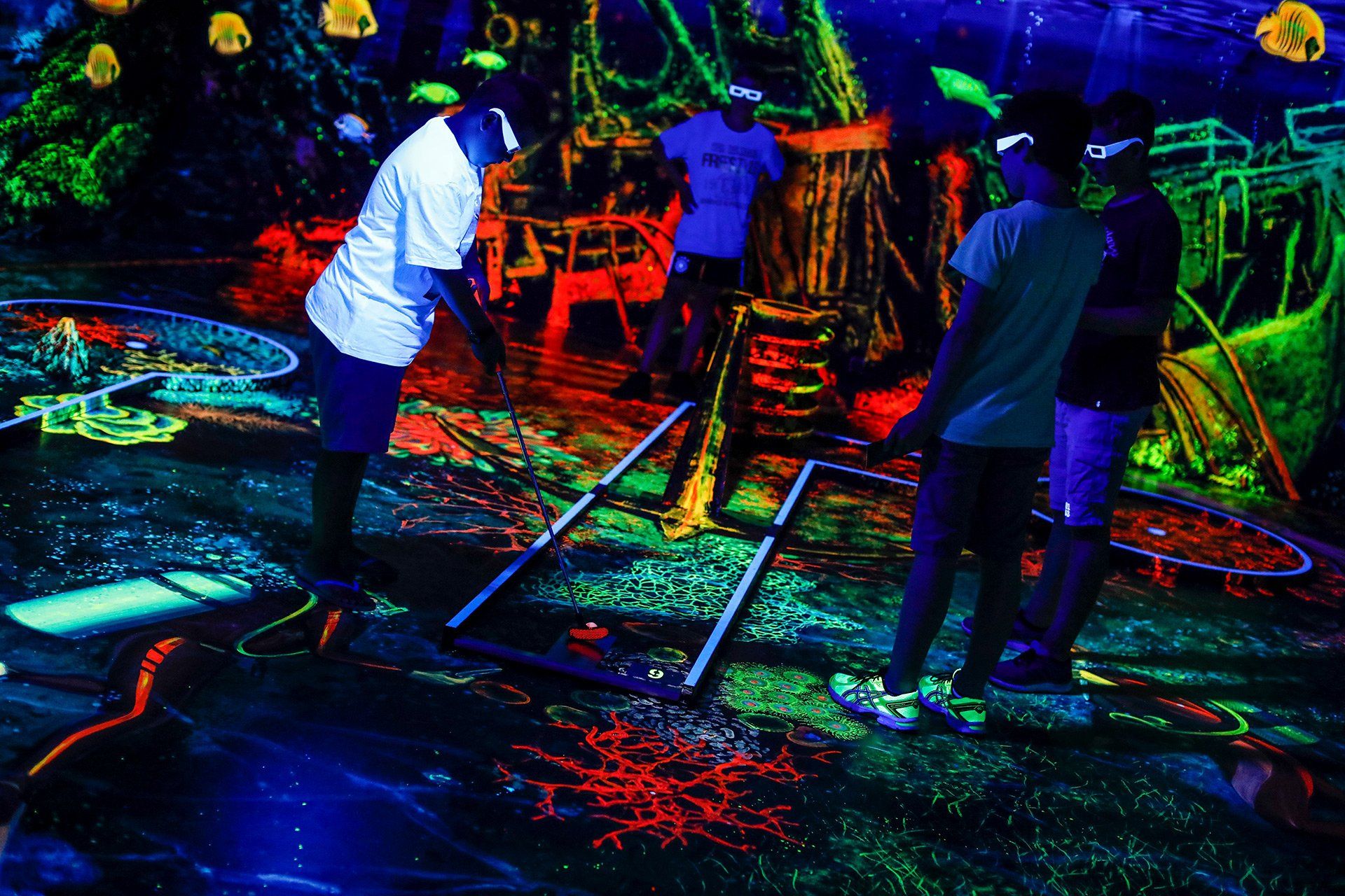 Kinder und Jugendliche spielen am 17.07.2018 im Rahmen der Ferienpass-Workshopwoche 3D-Schwarzlicht-Minigolf in Osnabrück. Foto: David Ebener ***Stichworte*** #Ferienpass, Ferienpass, Schwarzlichtminigolf. Schwarzlicht, Minigolf, Schwarzlicht Golf 3D, 3D-Schwarzlicht-Minigolf
