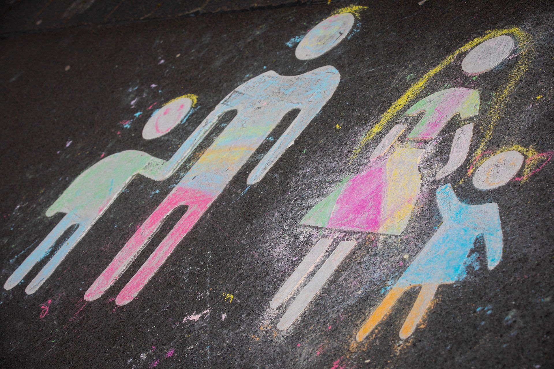 A pictogram of a family, embellished by children's hands with street chalk, taken on 20 April 2020 in the car park in front of the Ikea furniture store in Osnabrück, which was closed during the coronavirus pandemic. Photo: David Ebener ***Keywords*** Pictogram family, symbolic image, father, man, mother, woman, child, children, symbolic photo, illustration, Ikea, furniture, furniture store, chalk, street chalk, colourful, colour