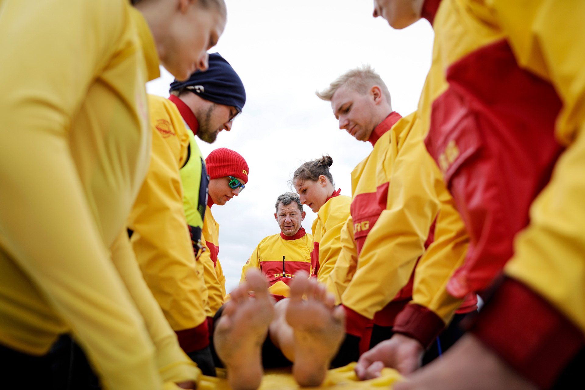 Wachführer Holger Hilbk (Mitte), Bootsführer Julian Pott (2. von rechts) und ihr Team von der DLRG Ortsgruppe Osnabrück bewachen am 15.07.2019 den 1.000m langen Strand in Pelzerhaken bei Neustadt in Holstein an der Ostsee. Die Zeit, in der sich nur sehr wenige Badegäste am Strand aufhalten, nutzt die Wachmannschaft für Rettungsübungen. Foto: David Ebener ***Stichworte*** #Samstagsreportage, Samstagsreportage, Reportage, Deutsche Lebens-Rettungs-Gesellschaft, Rettungsschwimmer, Wachmannschaft, Wachstation, Ehrenamt, Küste, Waterkant