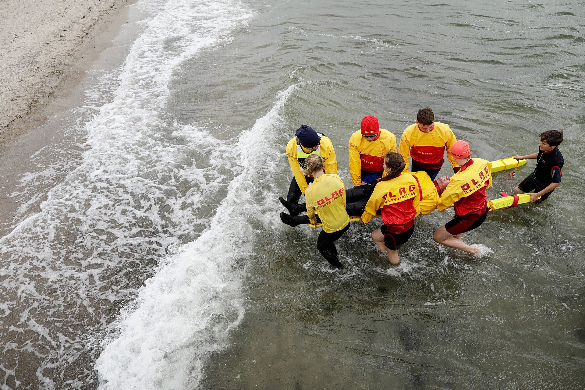 Bootsführer Julian Pott (auf dem Spineboard) und sein Team von der DLRG Ortsgruppe Osnabrück bewachen am 15.07.2019 den 1.000m langen Strand in Pelzerhaken bei Neustadt in Holstein an der Ostsee. Die Zeit, in der sich nur sehr wenige Badegäste am Strand aufhalten, nutzt die Wachmannschaft für Rettungsübungen. Foto: David Ebener ***Stichworte*** #Samstagsreportage, Samstagsreportage, Reportage, Deutsche Lebens-Rettungs-Gesellschaft, Rettungsschwimmer, Wachmannschaft, Wachstation, Ehrenamt, Küste, Waterkant
