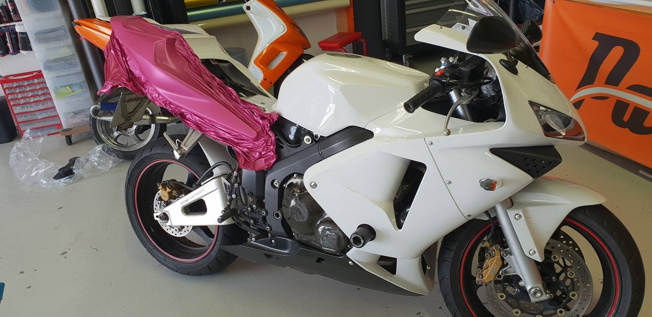 Umsetzung von pinker Folierung am Heck der Honda CBR in der Seitenansicht.