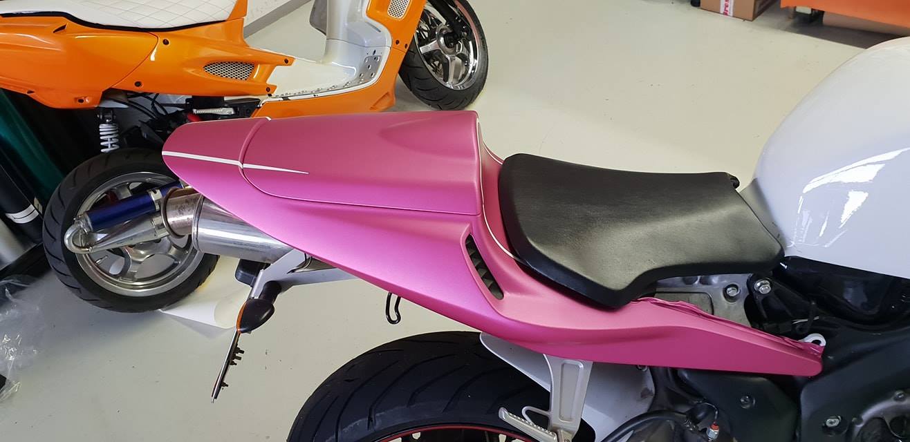 Heckansicht von Motorrad Honda CBR mit pinker Folierung.