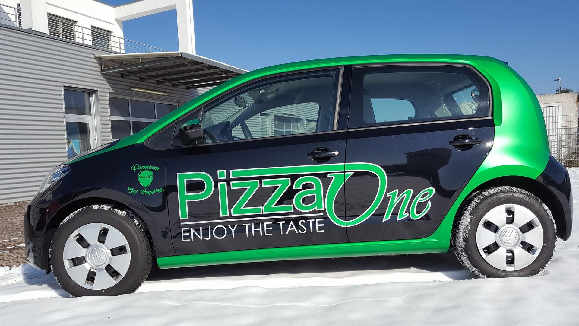 Seitenansicht von einem VW mit Fahrzeugbeschriftung für einen Pizza-Lieferservice.Folierung und