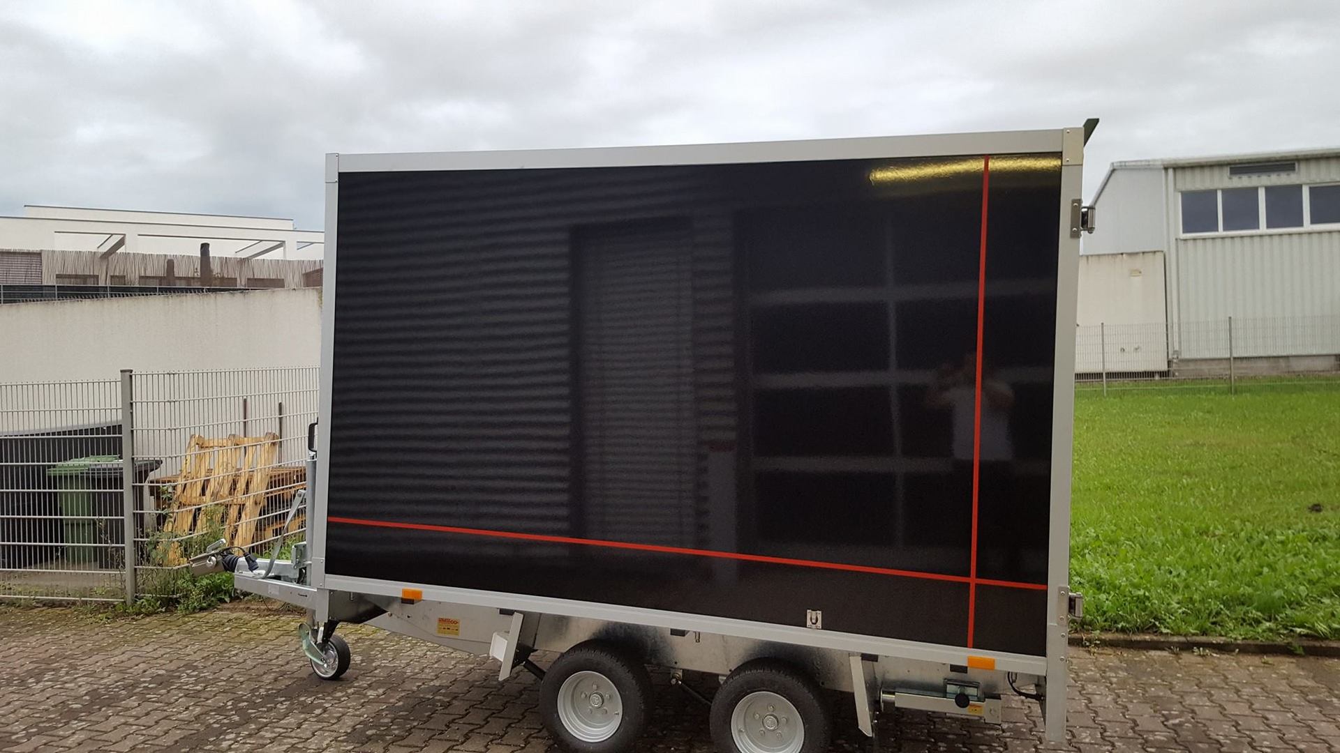 Anhänger vor Fahrzeugbeschriftung