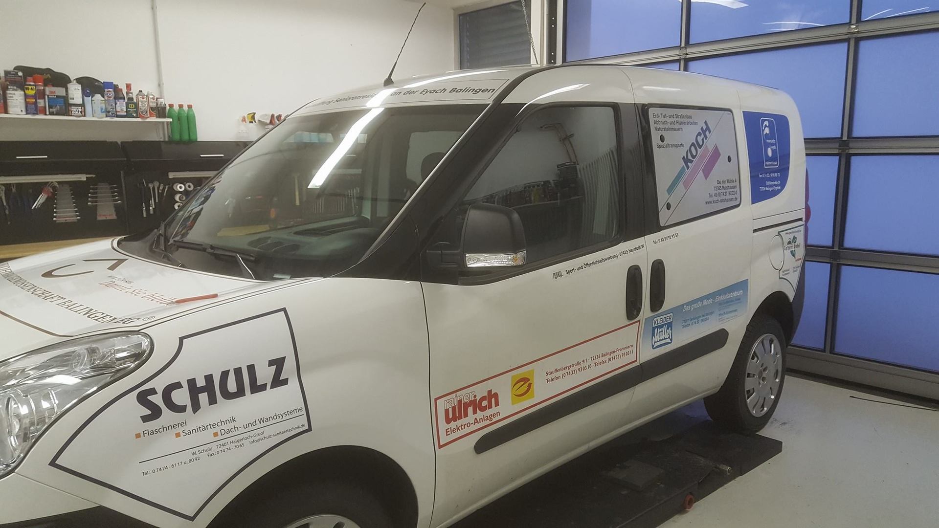 Fiat Doblo mit werbender Fahrzeugbeschriftung für eine Wohnbaugenossenschaft.