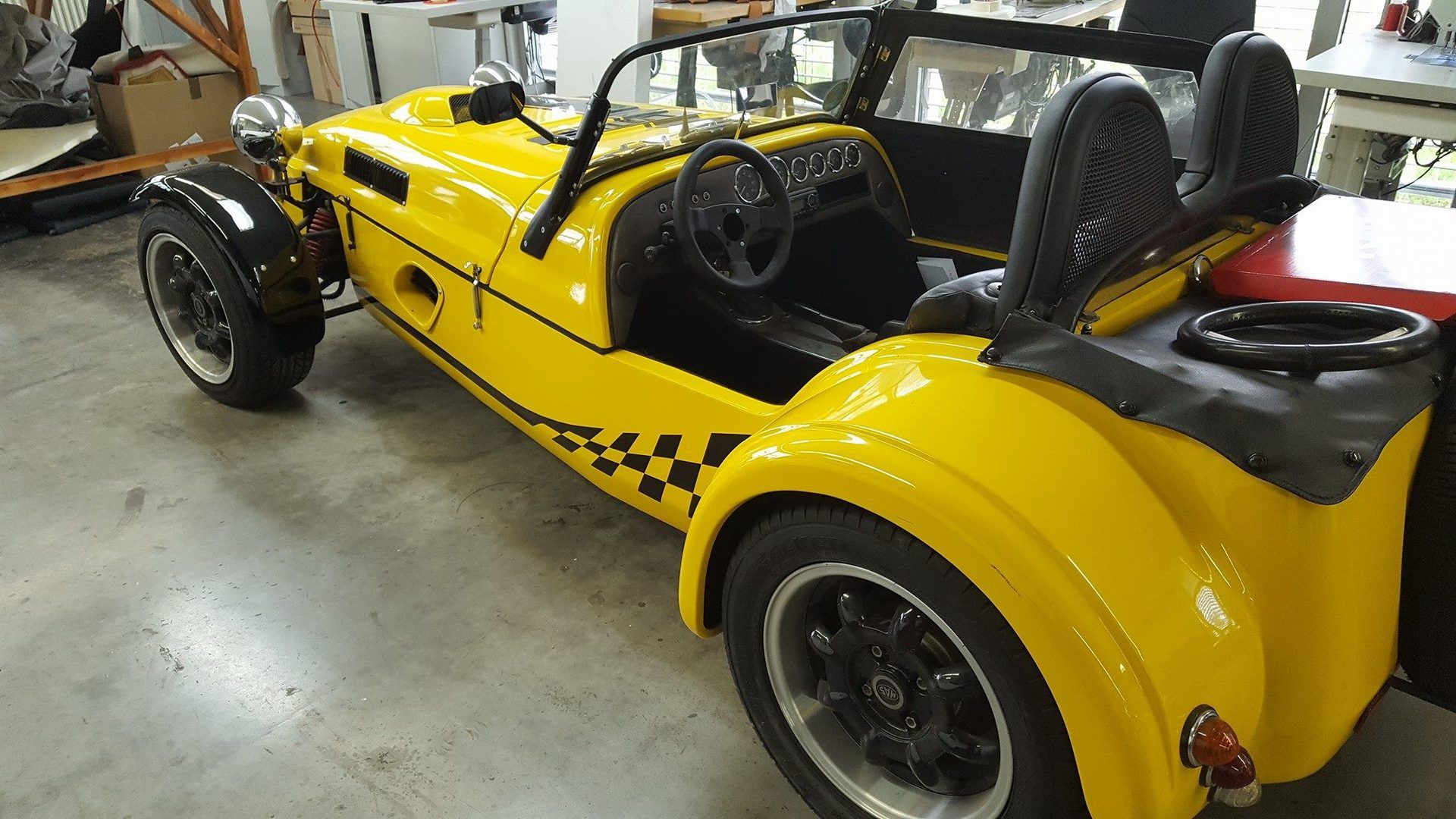 Hintere Seitenansicht von Lotus Super 7 mit schwarzer Folierung.