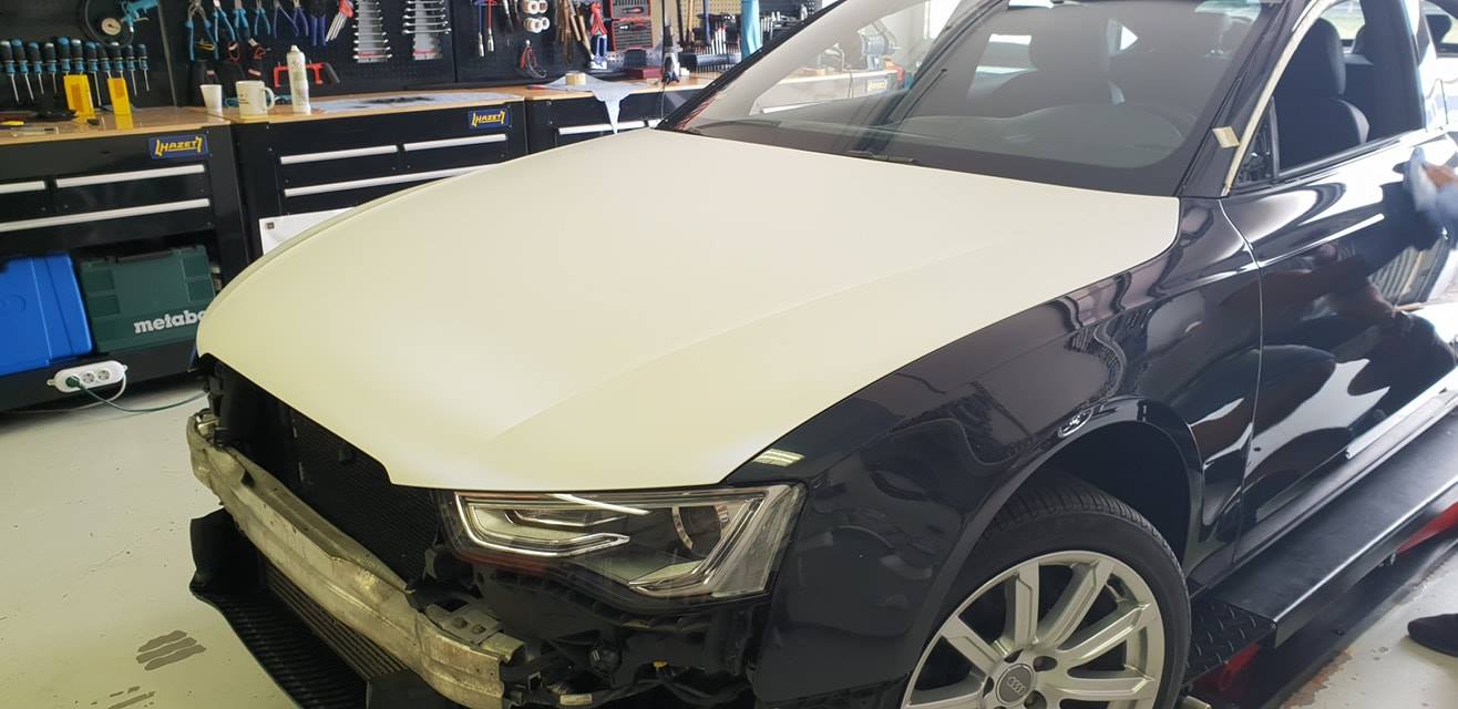 Umsetzung von weißer Folierung / Carwrapping an Audi A5. Detailansicht der Motohaube.