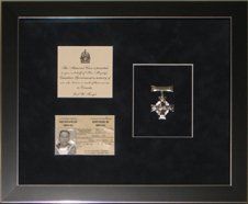 Certificate of service card and Memorial Cross with accompanied note framed in a black with silver pinstripes shadow box and black suede mats