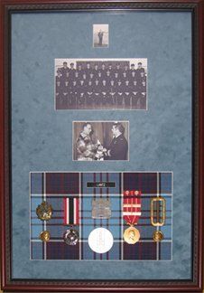 Photos, medals, medals, name tag, belt buckle framed in a mahogany shadow box with light blue suede mat and RCAF tartan