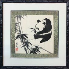 Pen & ink drawing of a panda and bamboo with green silk border framed in a black bamboo frame with cream and black mats