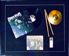 Breaker band photo, record and album cover, cymbal and drumsticks framed in a black shadow box with black mats