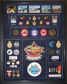 CF18 photos, RCAF badges, medallions, 416  and 409 Squadron badges framed in a black shadow box with blue suede mats
