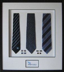 Ties and cufflinks shadow box Three ties, four pairs of cufflinks, and company name framed in a black shadow box with white and black mats
