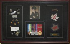 Portrait photo, medal rack, RCN uniform buttons and badges, bosun whistle framed in a mahogany shadow box with black suede mats