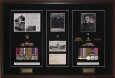 Medal racks and ribbon bars, pins, photos from multi generations framed in a mahogany shadow box with black suede mats