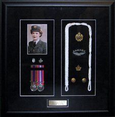 Portrait photo, medals and ribbon bar, lanyard, RCAF pins and uniform buttons framed in a black shadow box with black suede mats