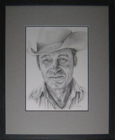 Pencil sketch of a cowboy's portrait framed in a distressed charcoal frame with grey and black mats