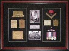 Portrait and group photos, medal rack and ribbon bar, bible, driver's handbook framed in a mahogany beaded shadow box with black suede mats