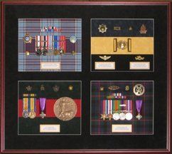 Multi generation military memorabilia: medal racks, Death Medal, VRI belt buckle, cap badges framed in a mahogany shadow box with black suede mats, tartan and regimental colour suede backgrounds