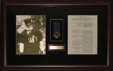 Photo of William Hall, a replica of his Victoria Cross and London Gazette notice framed in a mahogany shadow box with black suede mats