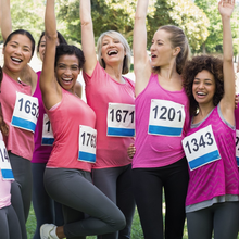 Photo of women with running numbers cheering