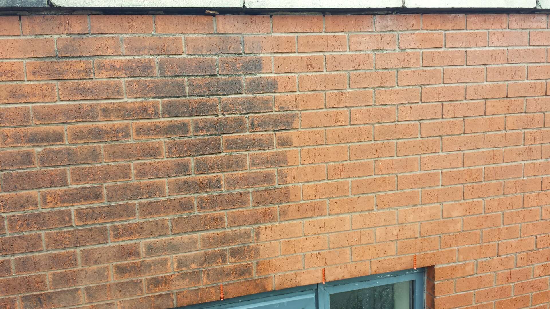 Before and after photo of cleaning dirt and carbon deposits off brick wall