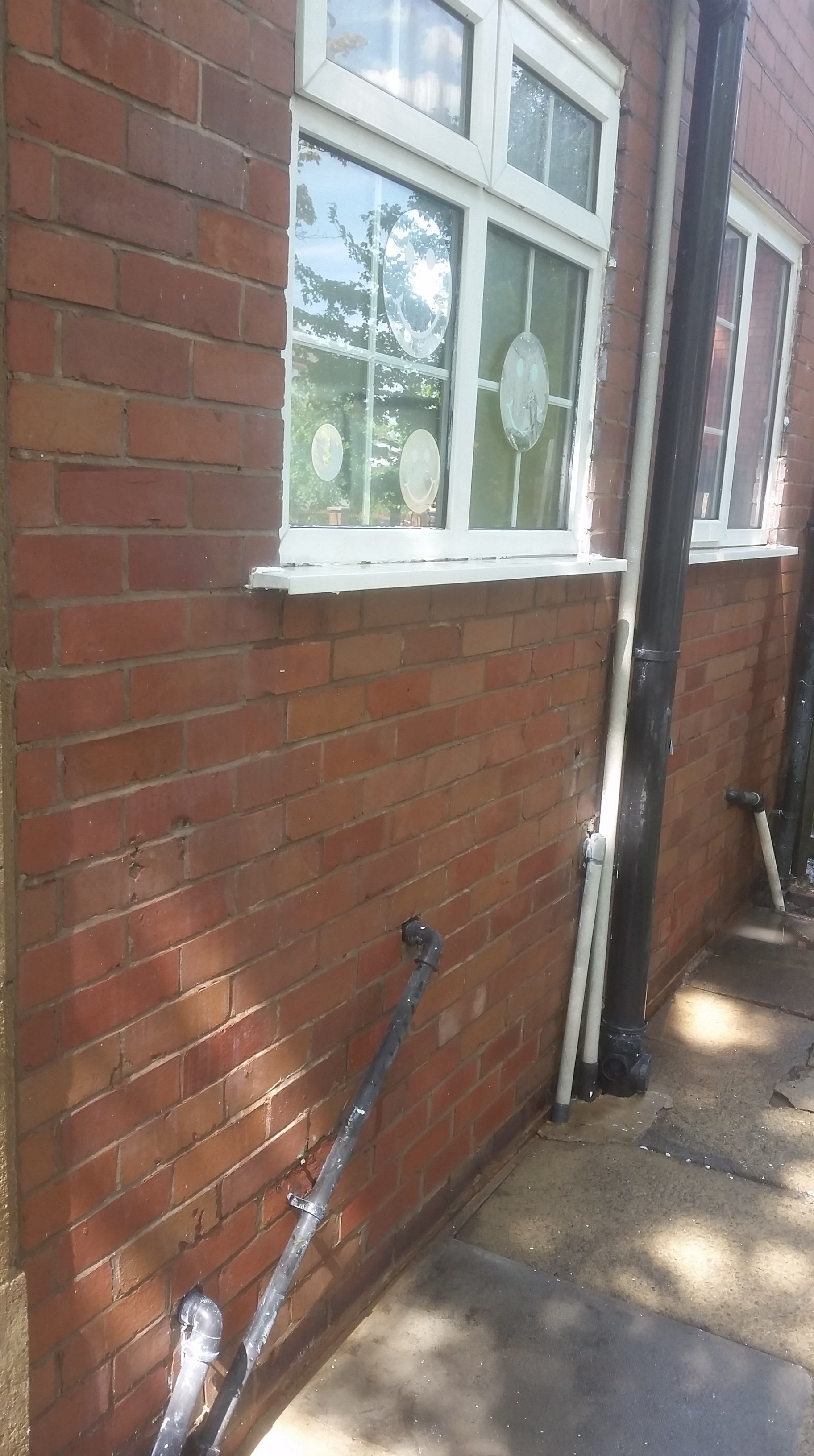 Brick wall with spilt paint and graffiti after cleaning