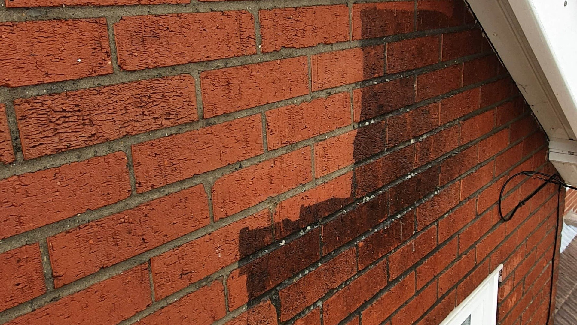 Before and after photo of cleaning dirt and carbon deposits off brick wall