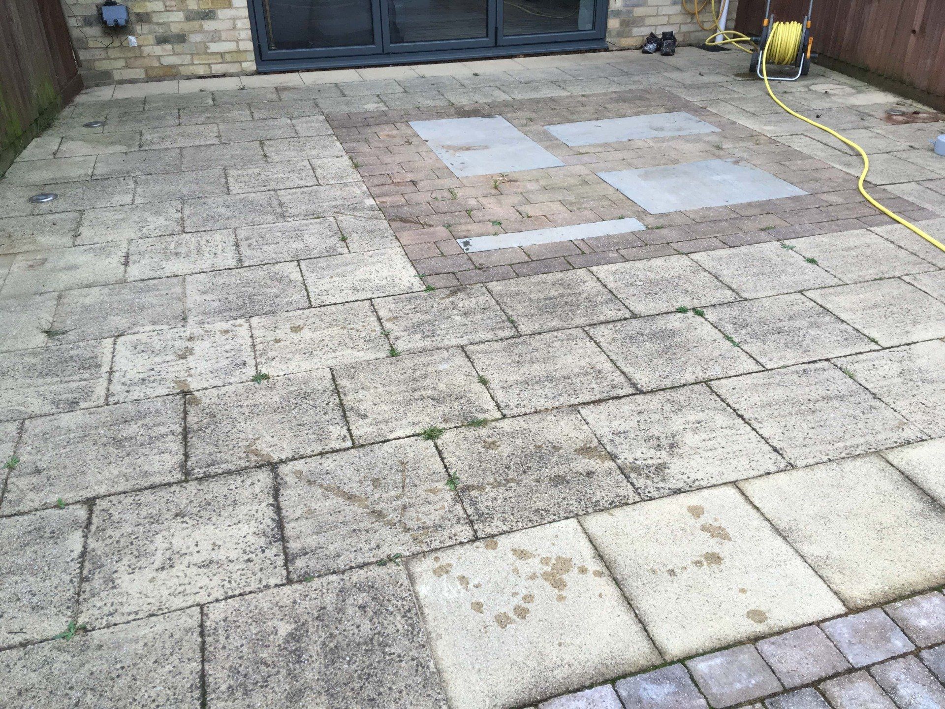 Concrete flag patio area with heavy Black Spot infestation before soft wash cleaning