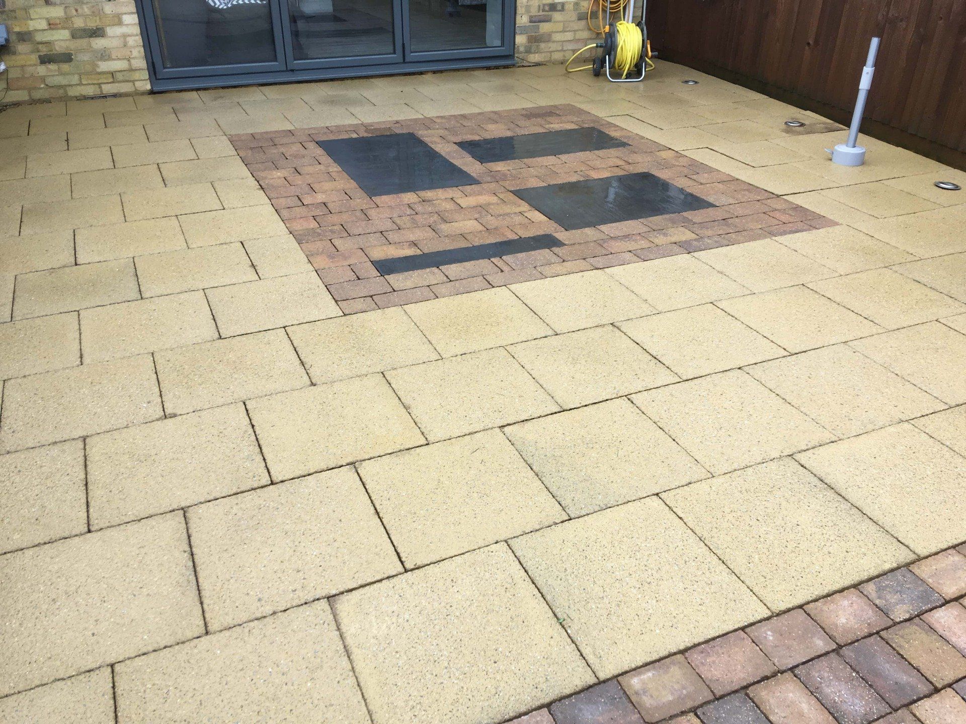 Concrete flag patio area with heavy Black Spot infestation after soft wash cleaning