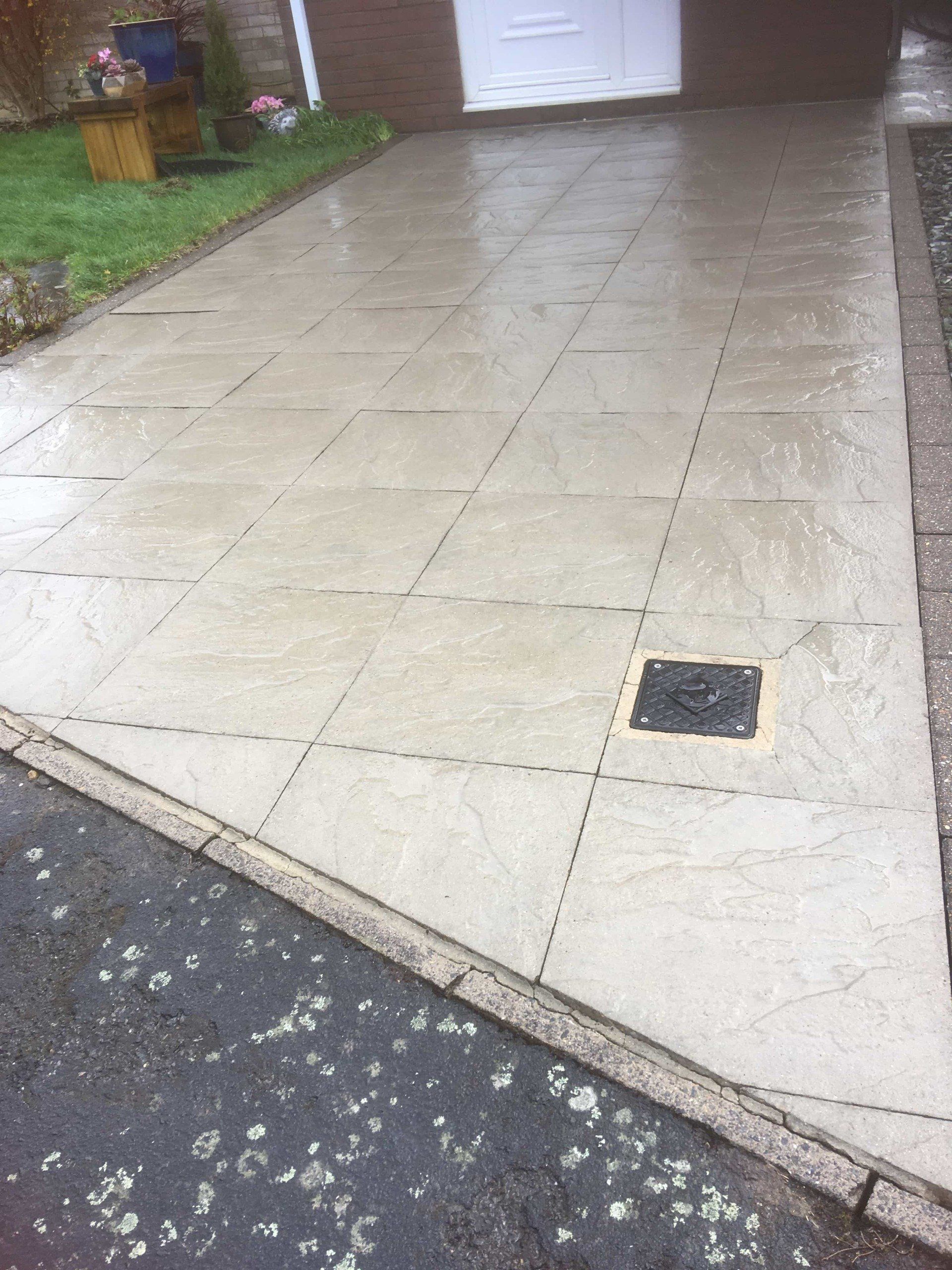 Dirty, lichen infested concrete flagged driveway after cleaning