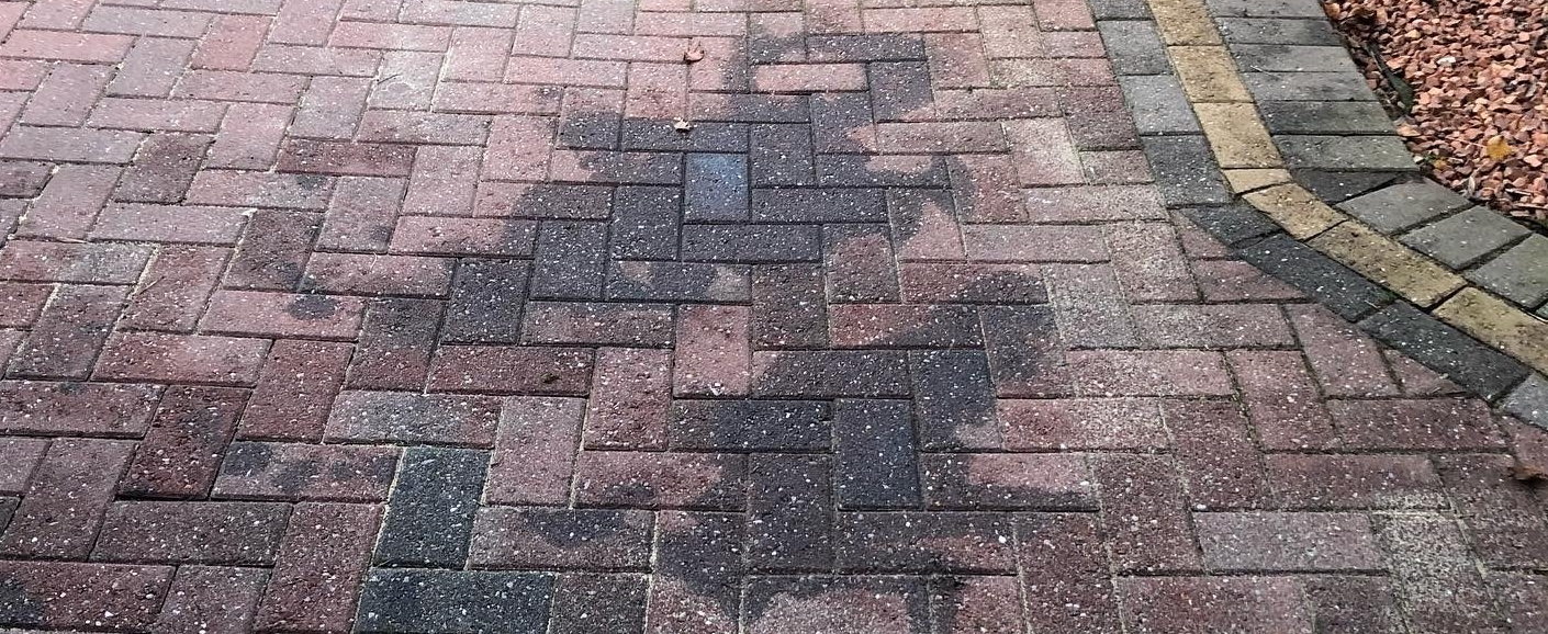 Oil stained block paving before cleaning