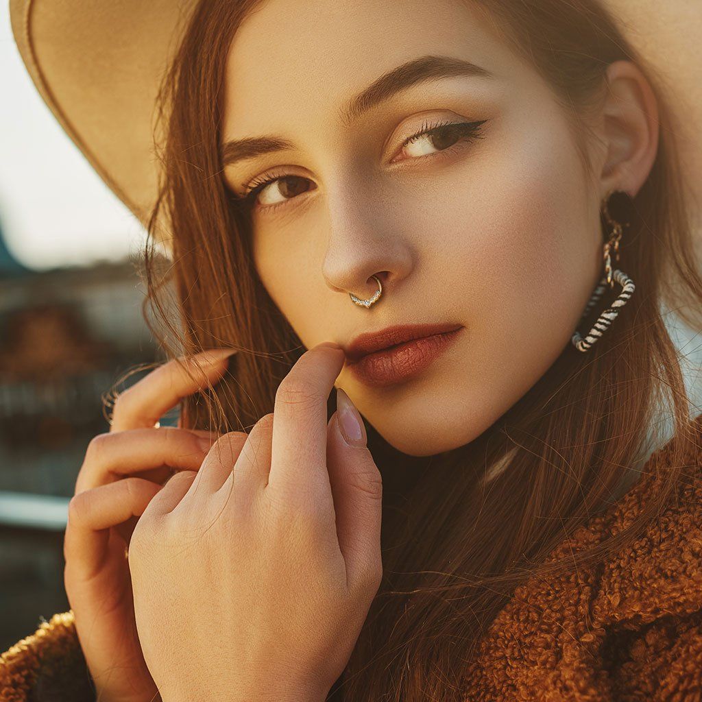 Junge Frau trägt ein Septum Piercing und Edelstahl Ohrringe