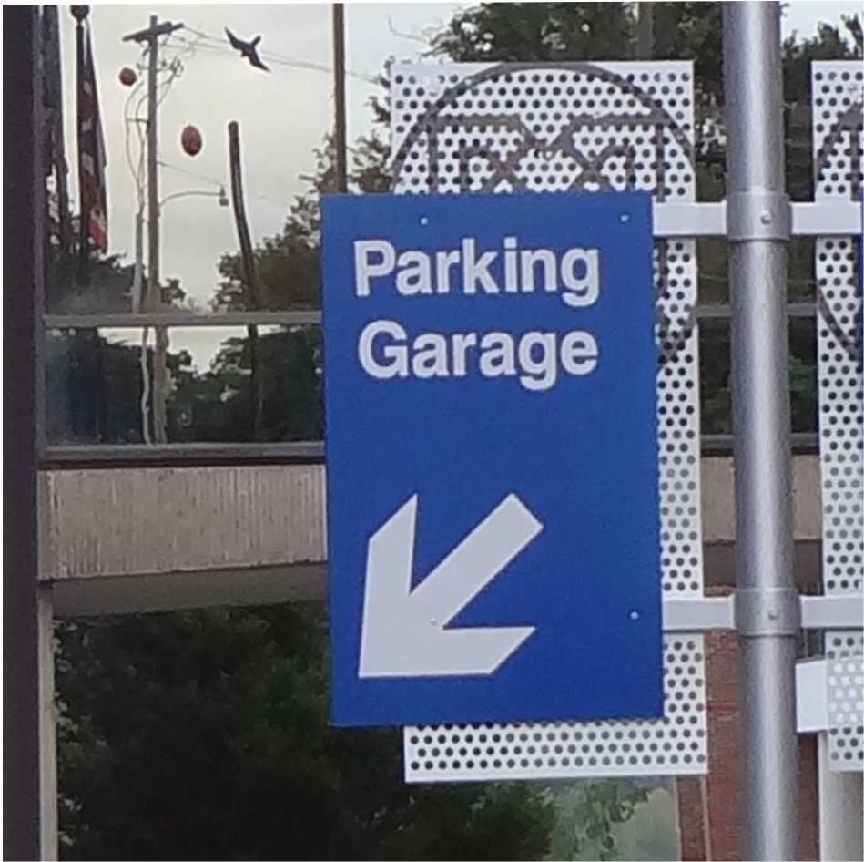DOUBLE FLAG MOUNTED SIGANE AT THE ENTRANCE TO A PARKING STRUCTURE