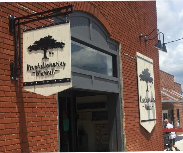 WOOD WITH METAL STRUCTURES WALL MOUNTED AND PROJECTING SIGNS HISTORIC DISTRICT SIGNAGE IDENTIFIES A SHOP