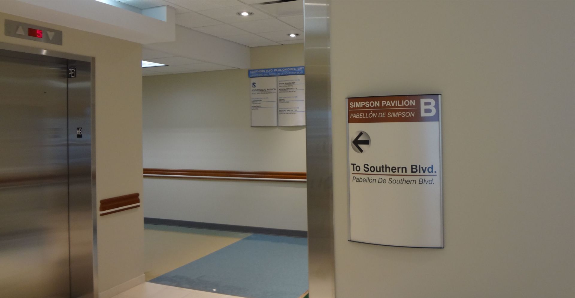 CURVED MODUAR VISTA SIGNAGE UNIFIED AND OLDER BUILDING WITH AN EXPANSION TO UNIFY ALL AREAS AND DIRECT USERS DESIGNED AND IMPLEMENTED BY COOPER SIGNAGE AND GRAPHICSIN ENGLISH AND SPANISH FOR THIS NYC FACILITY