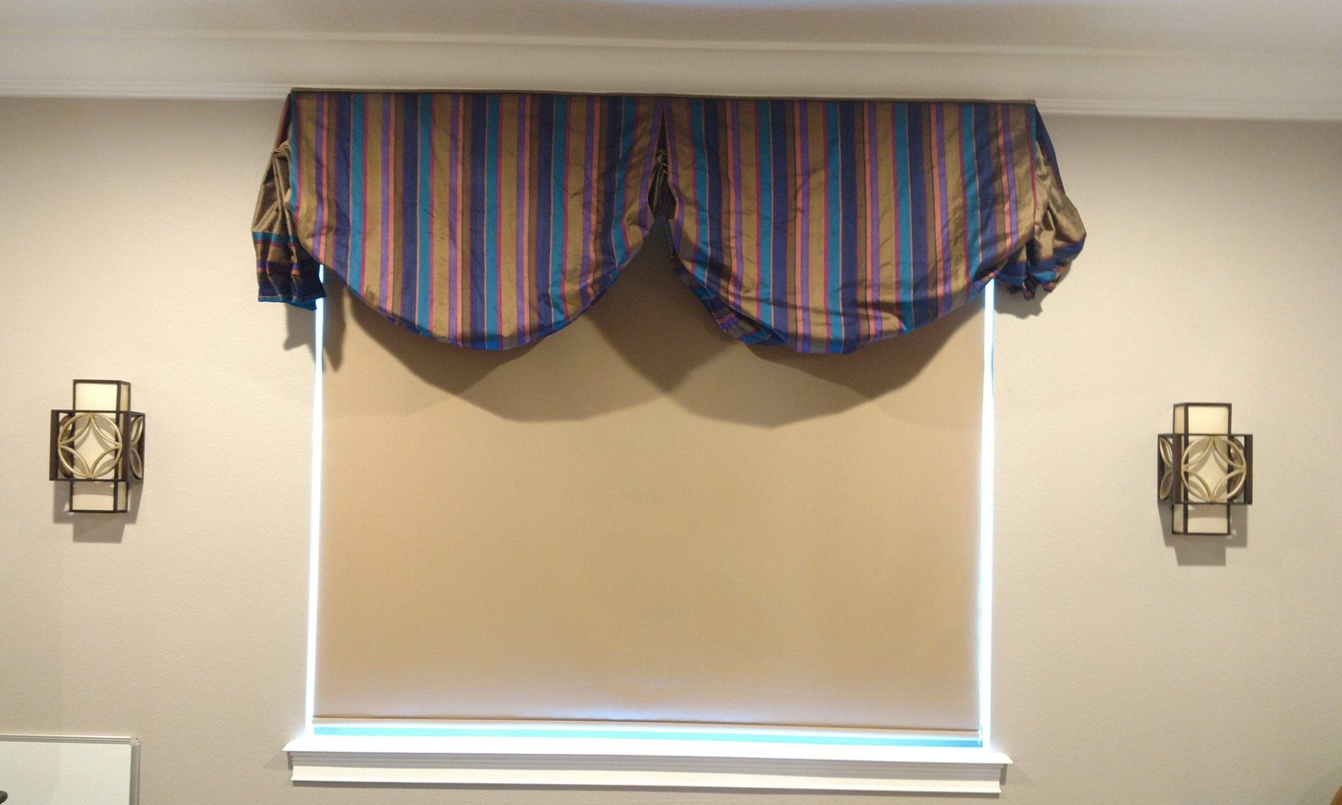 Colorful striped silk swag over cognac colored solar shade.