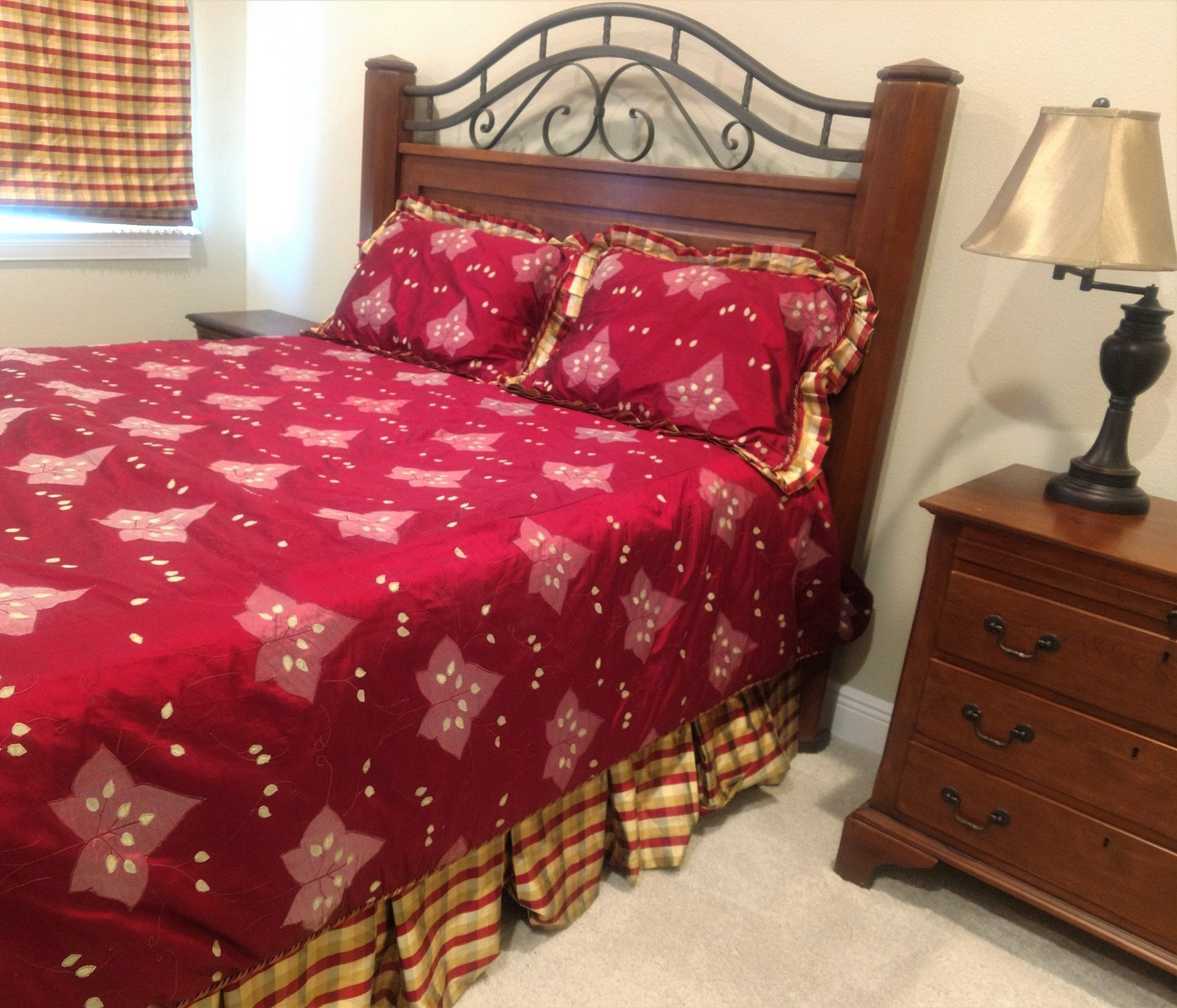 Custom embroidered silk duvet cover in crimson with coordinating dust ruffle and shade in striped fabric.