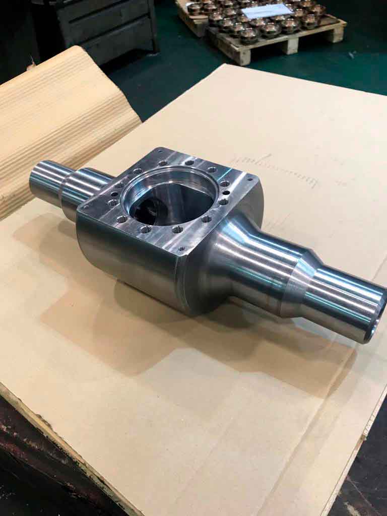 Pieza metálica mecanizada en CNC con ejes cilíndricos y alojamiento central, componente industrial de alta precisión.