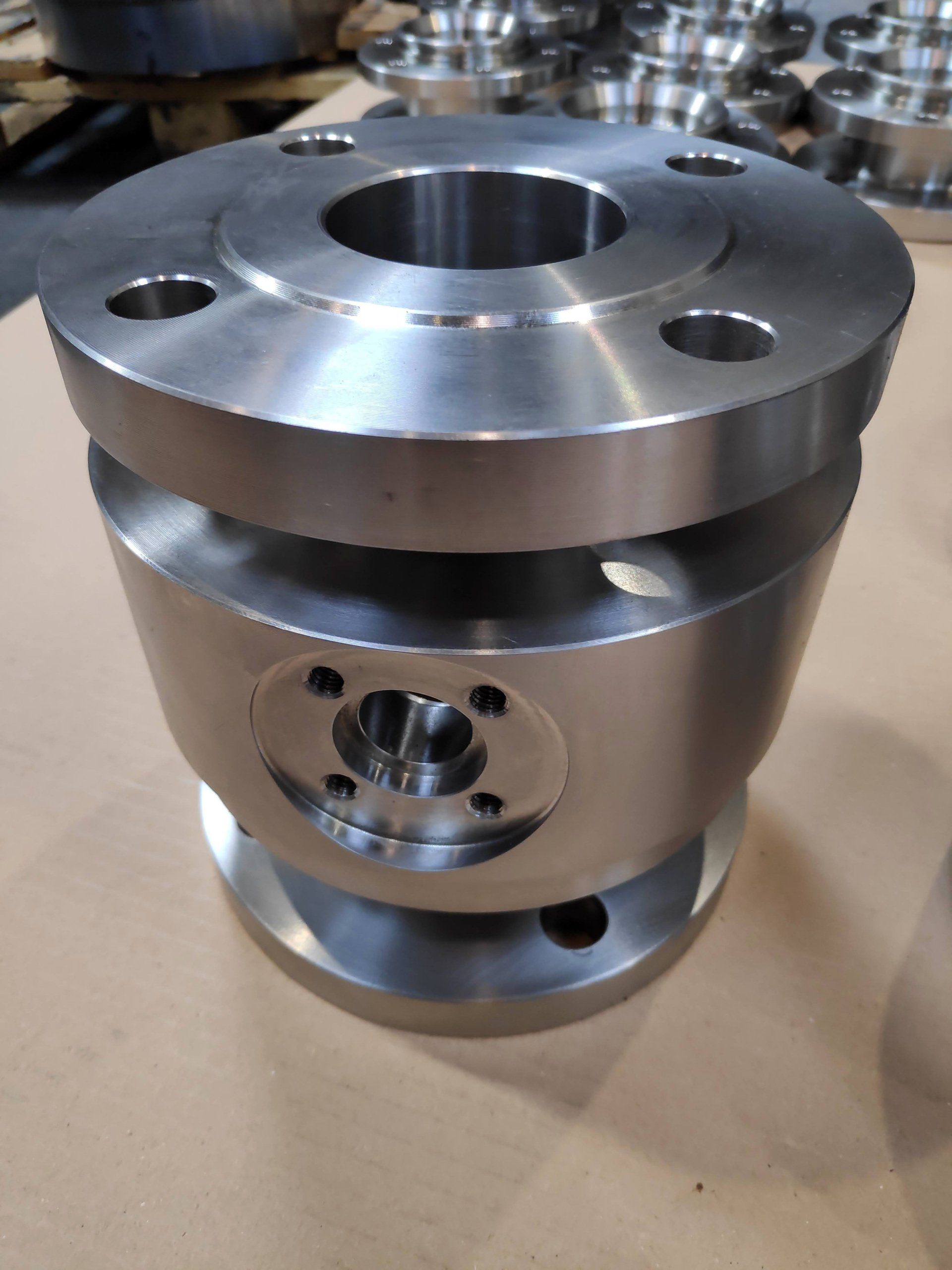 Conjunto de carcasa industrial mecanizada en CNC con bridas superiores e inferiores y alojamiento lateral de precisión.