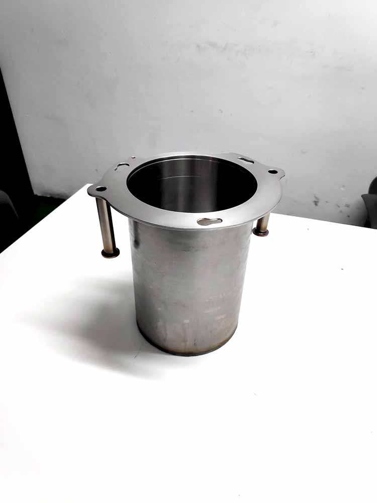 Cuerpo cilíndrico metálico mecanizado en CNC con brida superior y orificios de fijación, componente industrial de alta precisión.